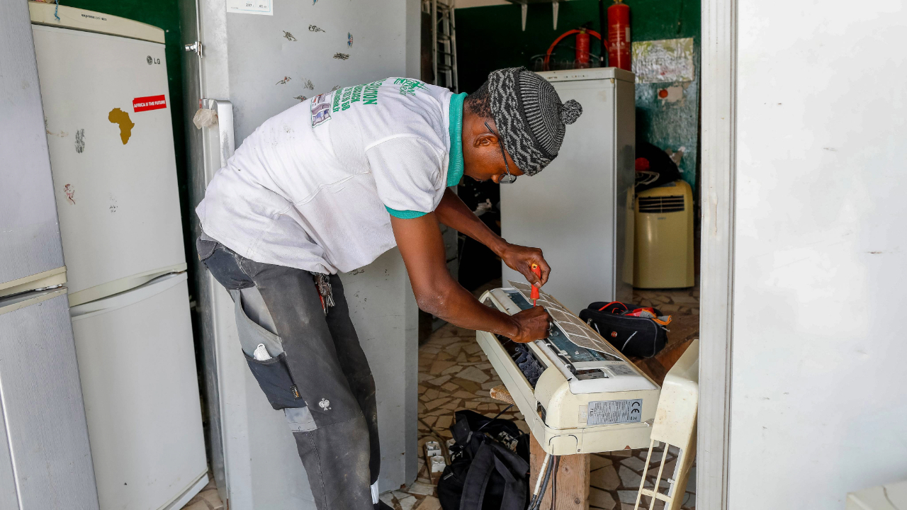 Un homme en train de réparer un climatiseur