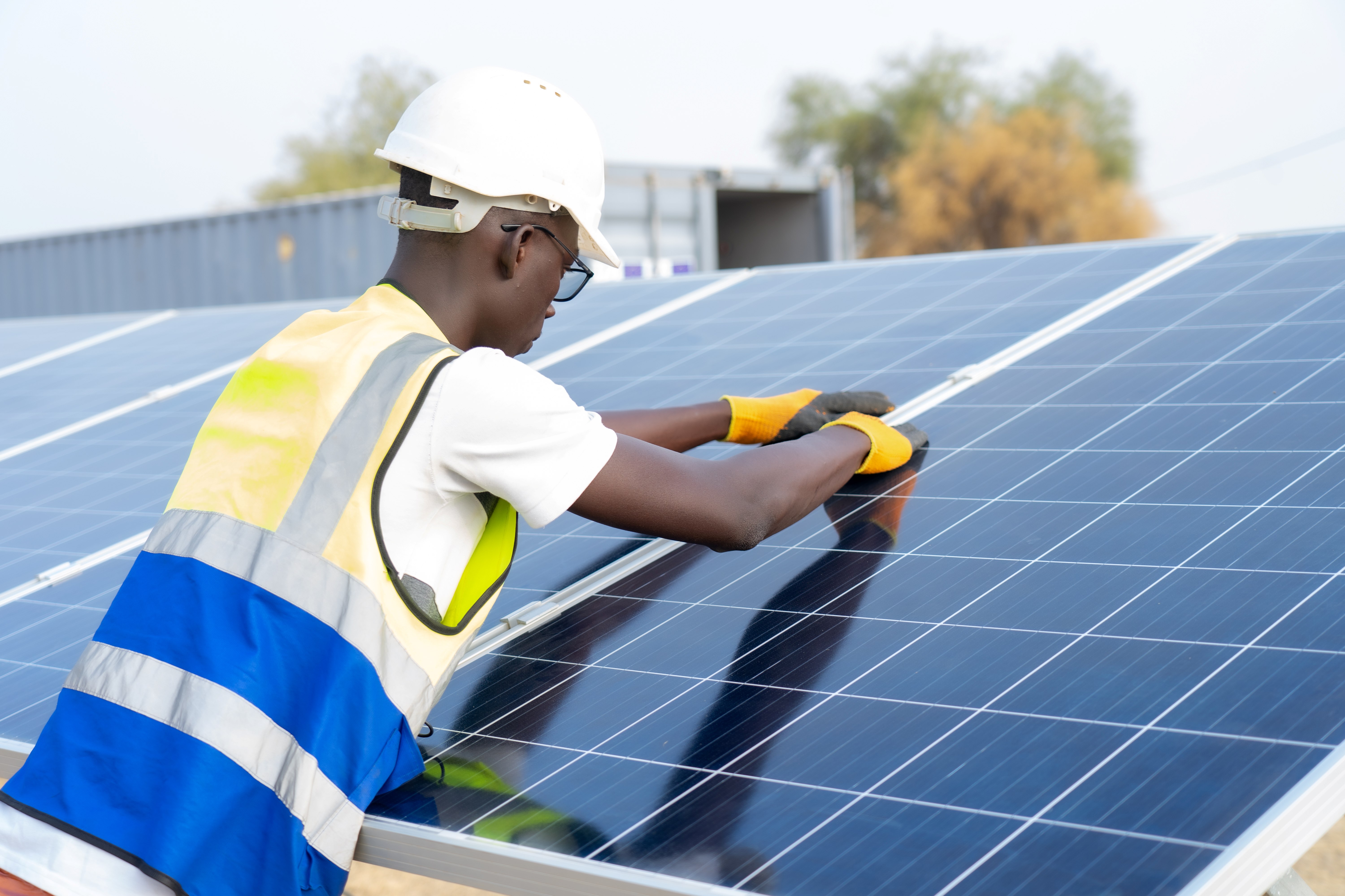 Un homme réparant des panneaux solaires