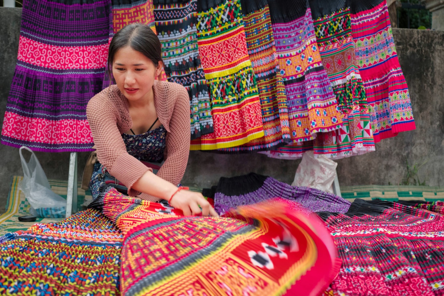 Une femme au Laos avec des tissus colorés