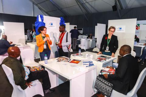 Des personnes discutent assises et debout autour d'une table