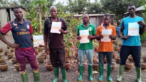 Cinq personnes debout avec des bottes tiennent en main un guide