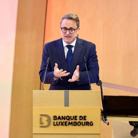 Xavier Bettel debout à un pupitre en train de faire un discours