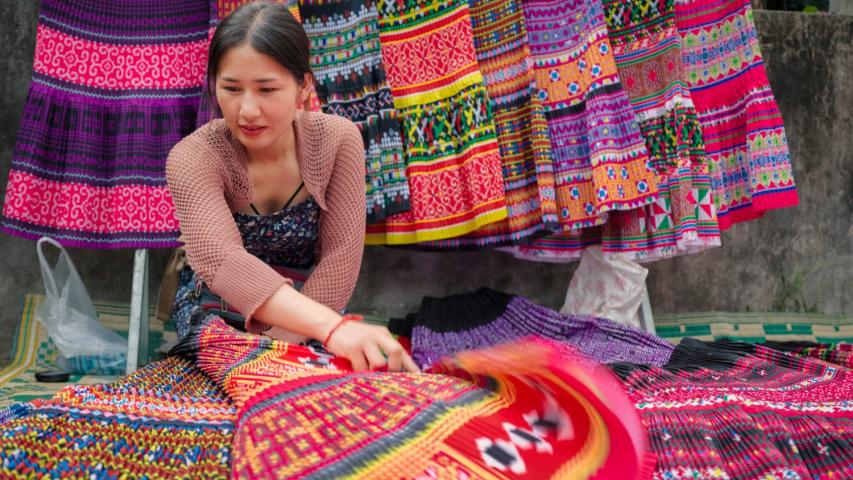 Une femme au Laos avec des tissus colorés