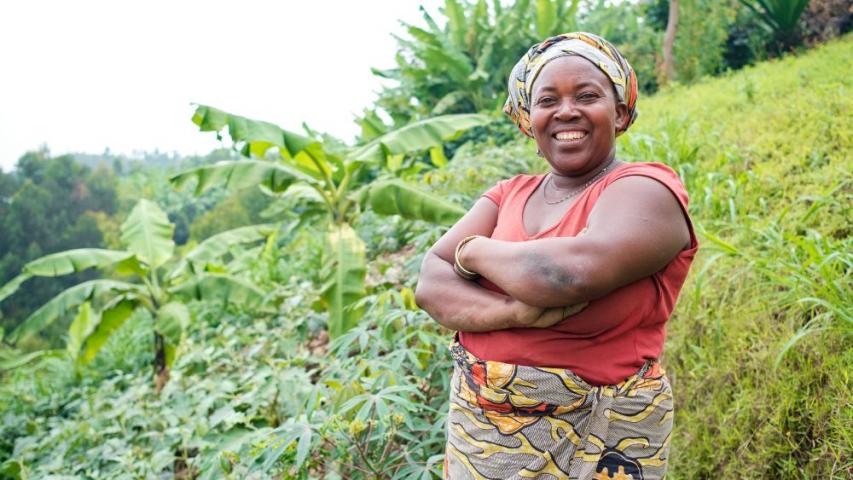 Une femme debout les bras croisés devant un paysage de forêts