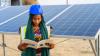 Une femme avec un casque bleu devant un panneau solaire